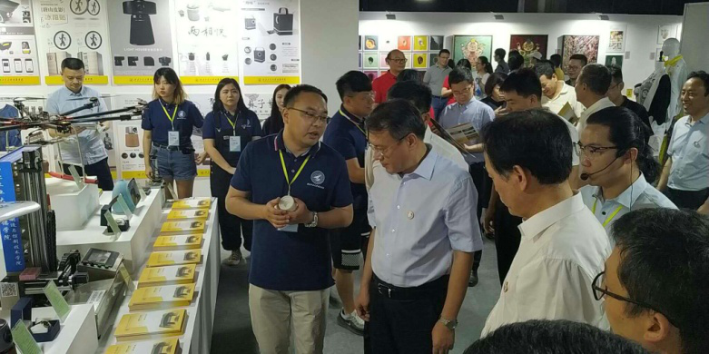 西安市委常委、副市長高杲在青博會聽取明德學院師生講解設(shè)計作品